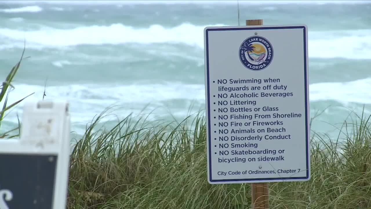 Lake Worth Beach sign at beach with list of rules and ocean waves in background, Dec. 14, 2023