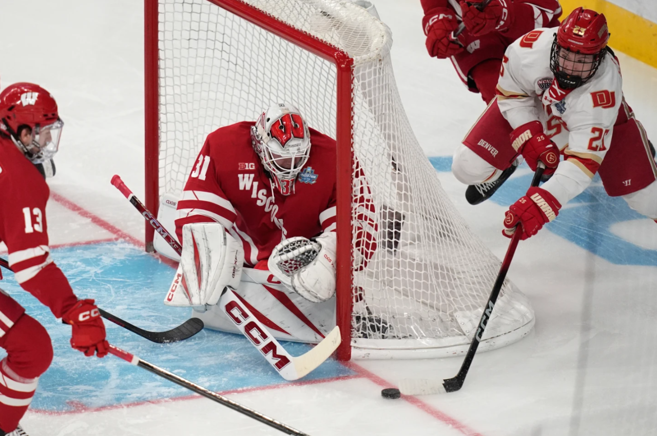 Denver forward Clarke Caswell (25) attempts a shot on Wisconsin goaltender Daniel Hauser (31) in the first period of the championship game at the NCAA Frozen Four men's college hockey tournament Saturday, April 11, 2026, in Las Vegas.