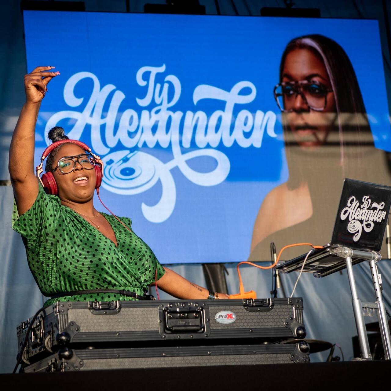 DJ TY WITH LOGO BEHIND HER.jpg