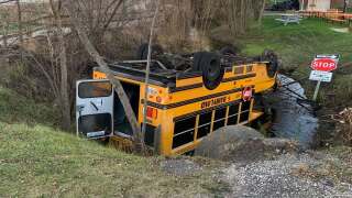 A car crash lead to a school bus rolling over into a pond and coming to a rest on its roof in Norway, near State Hwy 36 an Wind Lake Road. 