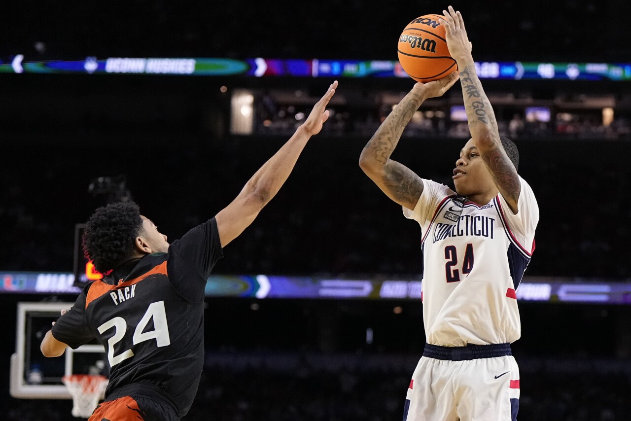 Connecticut Huskies guard Jordan Hawkins shoots over Miami Hurricanes guard Nijel Pack in second half of Final Four, April 1, 2023