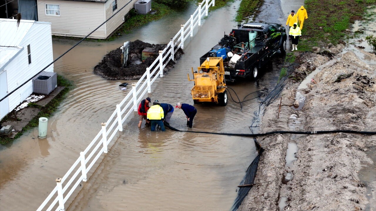Crews knee deep in water working to pump it away from the mobile homes in Moss Landings.