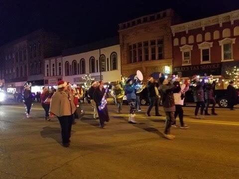 People are walking in the Lighted Holiday Parade