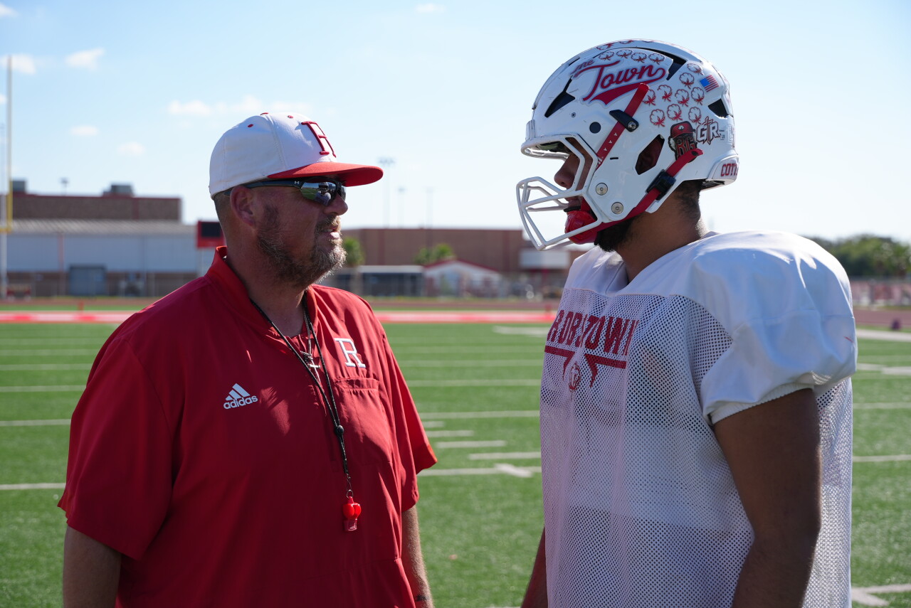 Robstown football head coach Travis Crowley with a player