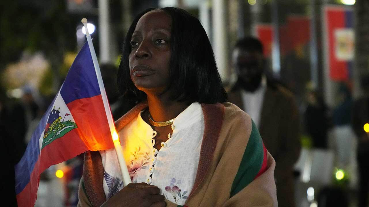 Linda Joseph holds a candle during a vigil at the Little Haiti Cultural Complex after a federal judge blocked the Trump administration from ending temporary immigration status, or TPS, for Haitians, Tuesday, Feb. 3, 2026, in North Miami. (AP Photo/Lynne Sladky)