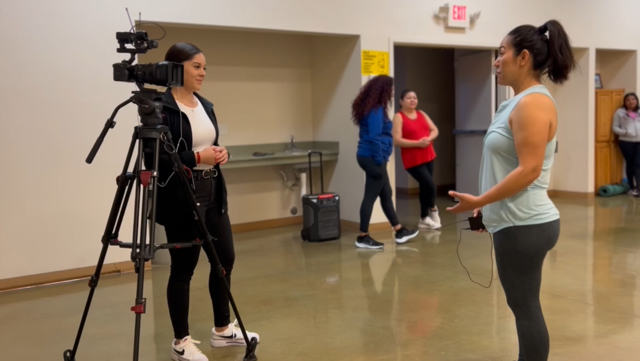 Neighborhood News Reporter Priscilla Lara interviewing volunteer Xenia Gaytan about the health benefits of Bailoterapia