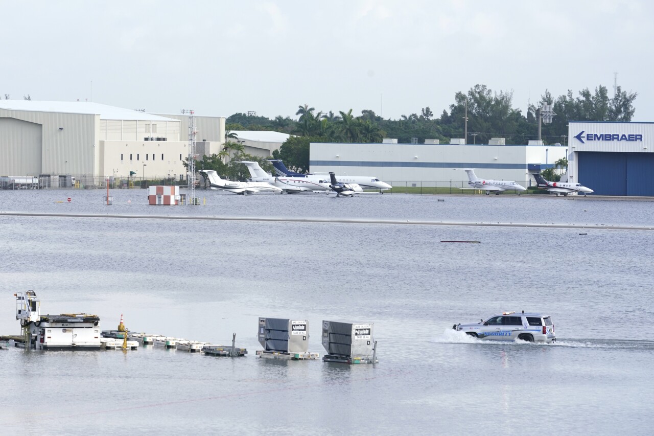 Truck drives through flooded runway at Fort Lauderdale-Hollywood International Airport, April 13, 2023