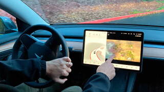 FILE - Vince Patton, a new Tesla owner, demonstrates on Dec. 8, 2021, on a closed course in Portland, Ore., how he can play video games on the vehicle's console while driving. The U.S. has opened a formal investigation into a report that Tesla vehicles allow people to play video games on a center touch screen while they are driving. (AP Photo/Gillian Flaccus, File)