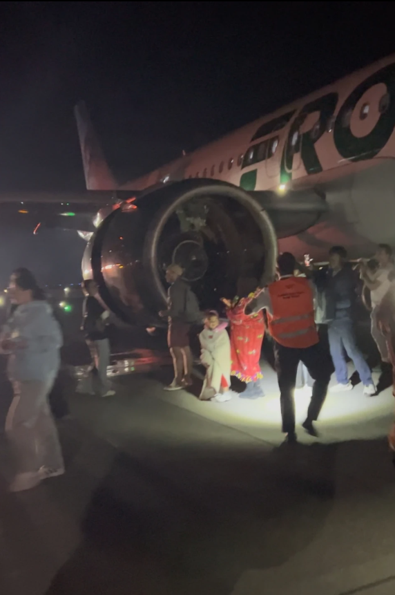 This image provided by Jack Estenssoro, passengers evacuate an airplane after a person was struck and killed by a Frontier Airlines plane during takeoff, at Denver International Airport, Friday, May 8, 2026, in Denver.