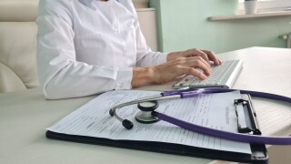 Doctor,Typing,Medical,Records,On,Computer,In,Office