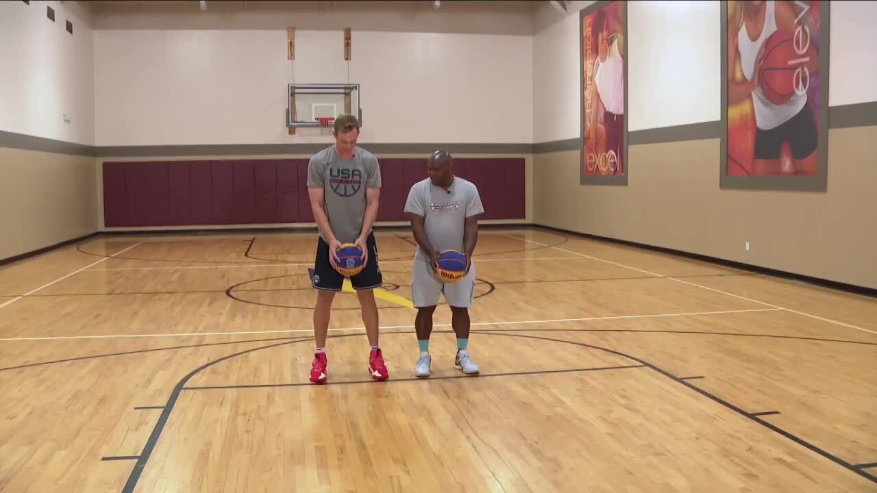Canyon Barry teaches Todd Wilson how to shoot a free throw underhanded