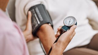 Stock image of a health care professional checking a patient's blood pressure.