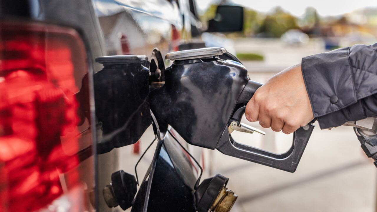 Fueling,Car,At,Gas,Station,With,Closeup,Of,Hand,Holding
