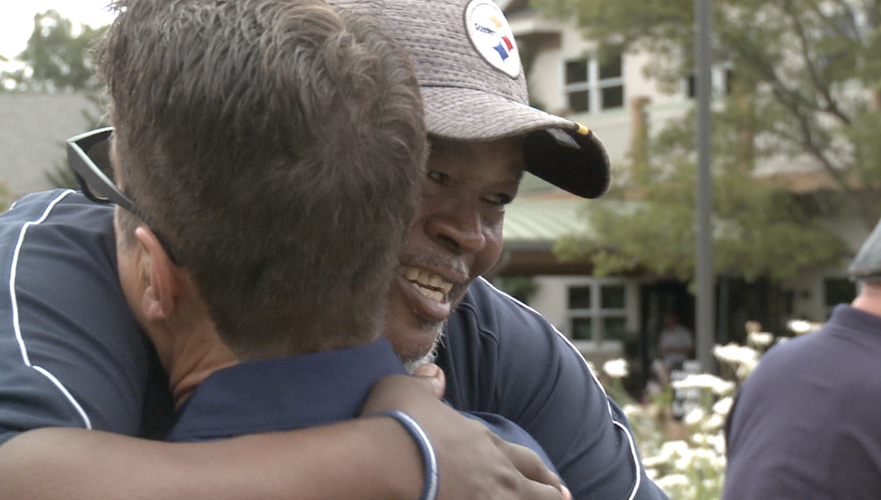 Russell Davis shares a hug at Monday's golf outing