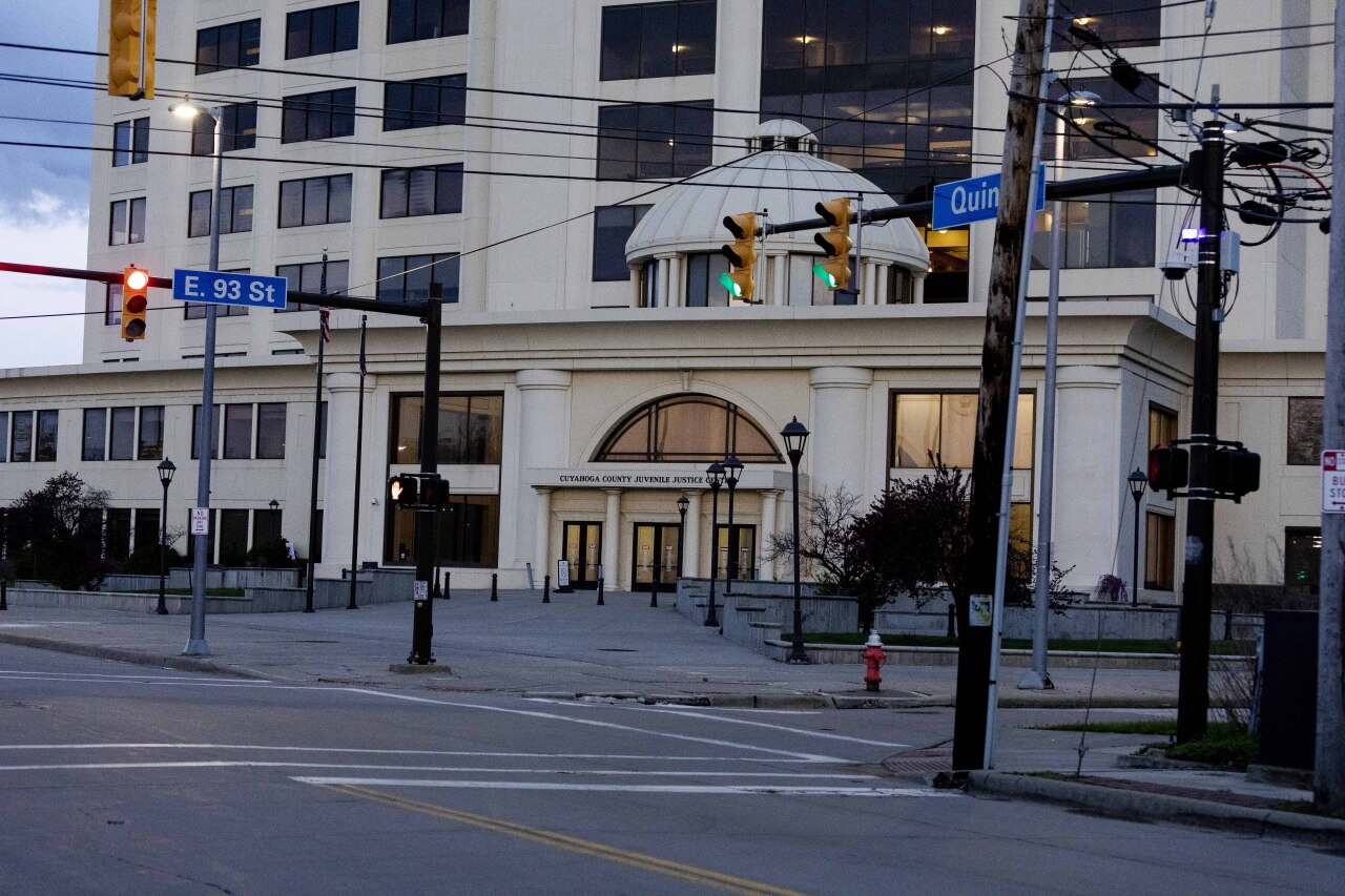 Traffic lights are on in front of the Cuyahoga County Juvenile Justice Center at dusk.