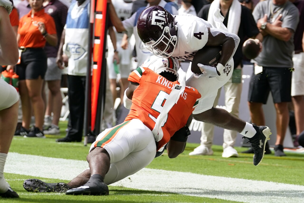 Texas A&M Aggies running back Amari Daniels tackled by Miami Hurricanes safety Kamren Kinchens during first half, Sept. 9, 2023