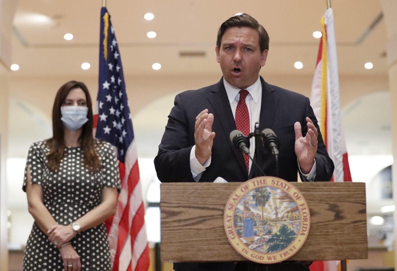 Gov. Ron DeSantis at news conference while Lt. Gov. Jeanette Nunez wears mask