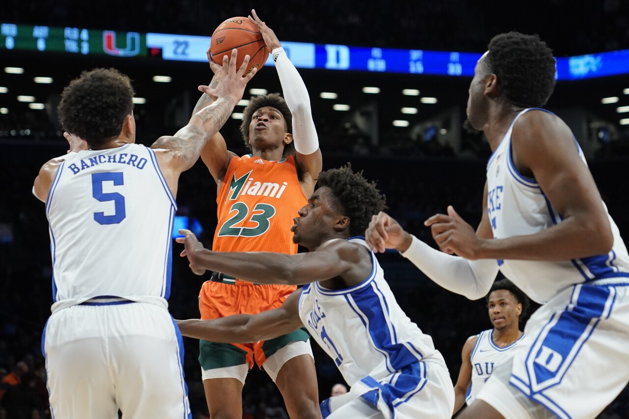 Miami Hurricanes guard Kameron McGusty shoots over Duke Blue Devils forward Paolo Banchero in 2022 ACC Tournament semifinal