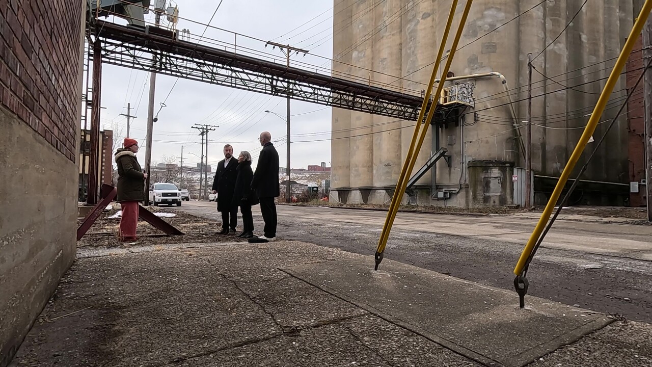 News 5 reporter Michelle Jarboe, left, talks to members of the development and design team who hope to transform the former Grain Craft mill in the Flats into a 147-room hotel.