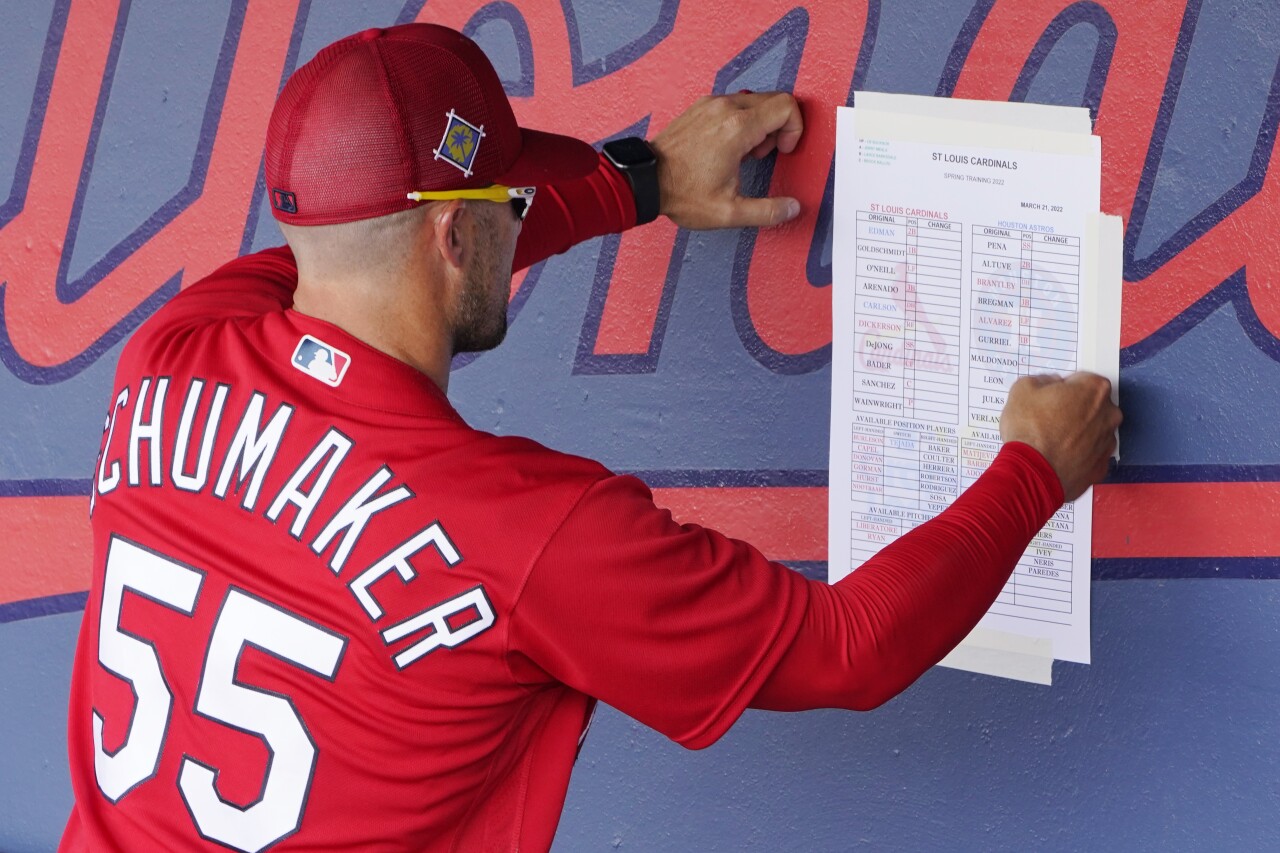 St. Louis Cardinals bench coach Skip Schumaker tapes lineup to dugout before spring training game in 2022