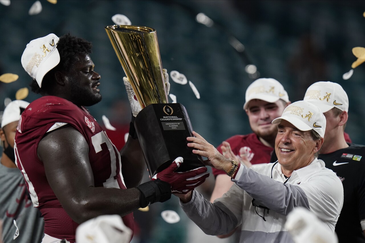 Alabama Crimson Tide head coach Nick Saban and offensive lineman Alex Leatherwood hold trophy after winning 2021 College Football Playoff National Championship
