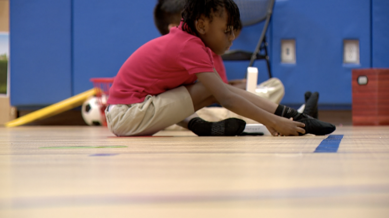 Child puts on ballet shoes