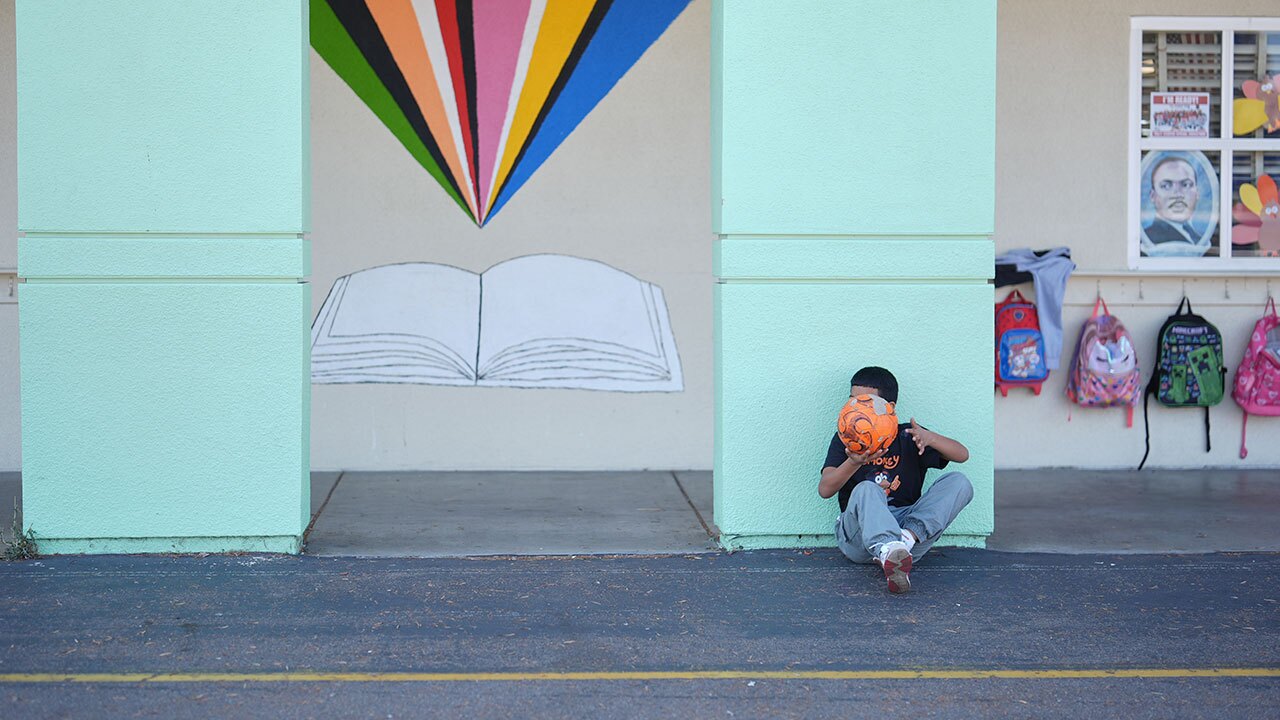 A student takes a break from soccer during recess at Perkins K-8 School Thursday, Nov. 13, 2025, in San Diego. (AP Photo/Gregory Bull)
