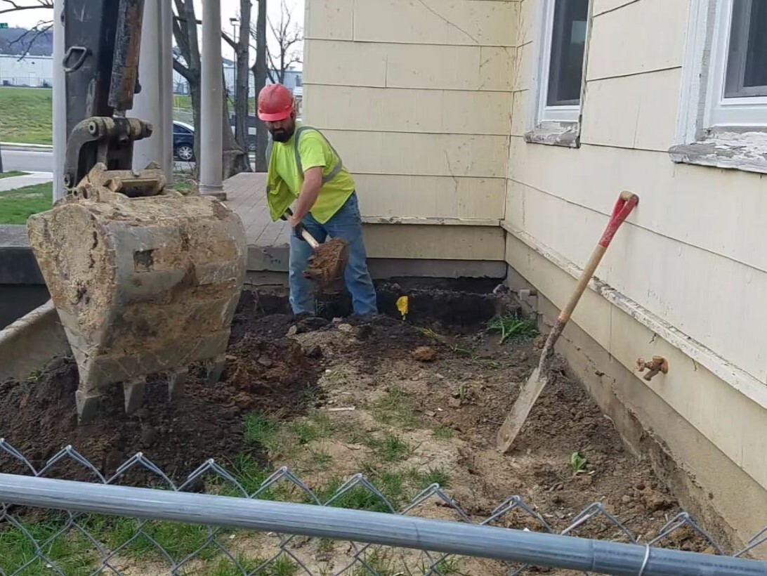 Greater Cincinnati Water Works hired the contractors who replaced Venus Kent's water service line in 2018. In this photo, a man in a hard hat is digging in her front yard.