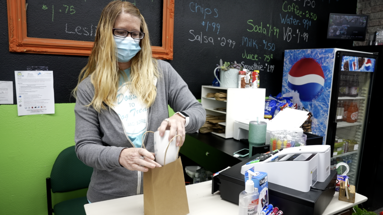 Erica Parr is wrapping up a mug and putting in the bag.
