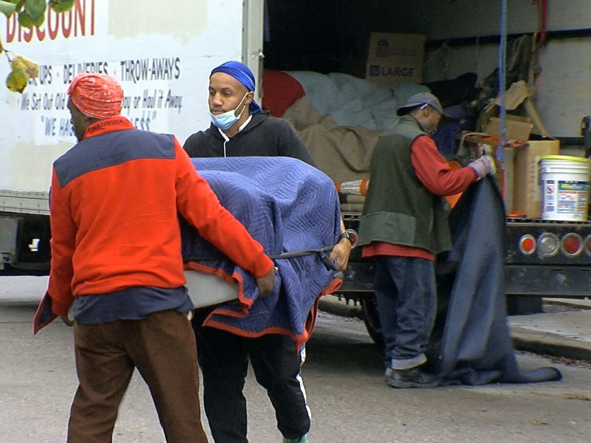 Movers unload Valerie Lane's possessions to take them into her new home.