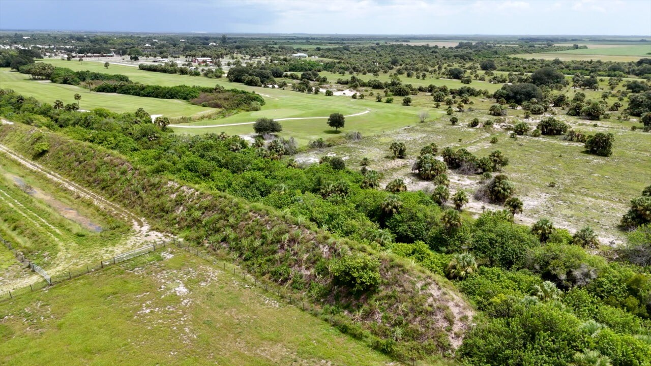 Aerial view of berm with golf course in background