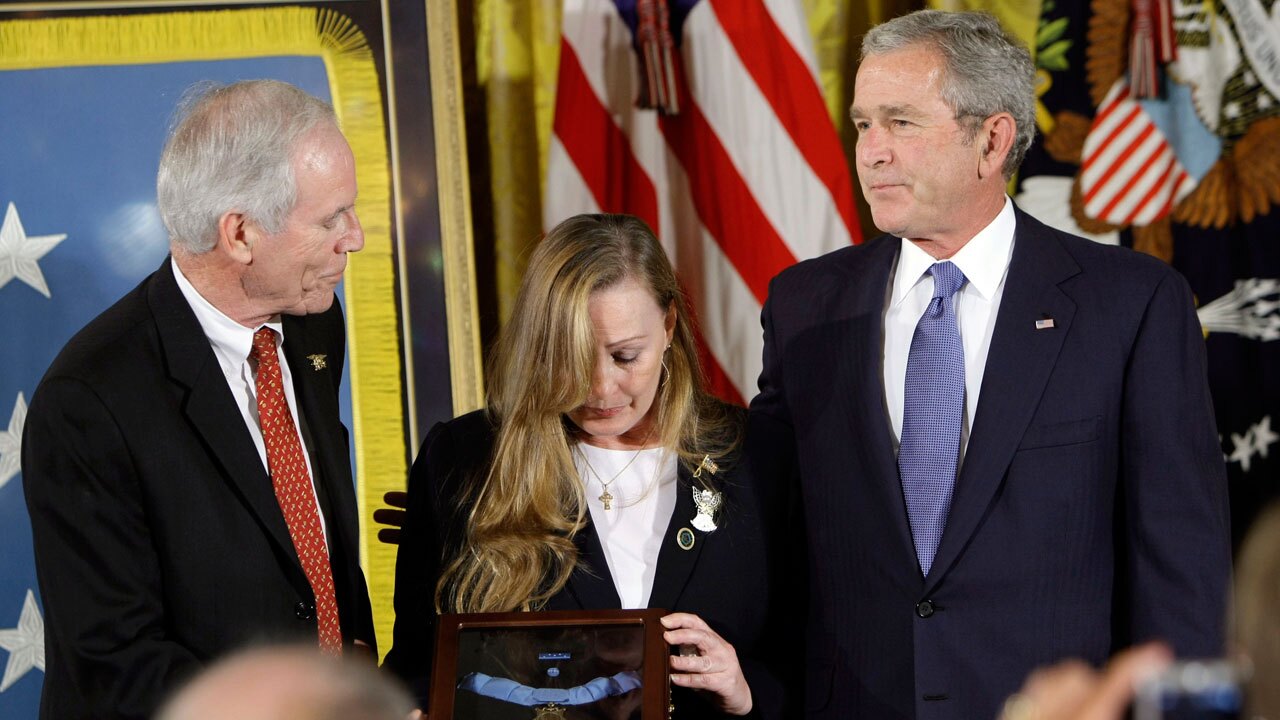 President Bush, right, presents the Medal of Honor, posthumously honoring Navy Seal Lt. Michael Murphy of Patchogue, N.Y., for combat in Afghanistan, in a ceremony to his parents Daniel, left, and Maureen Murphy, center, Monday, Oct. 22, 2007, during a ceremony in the East Room of the White House in Washington.