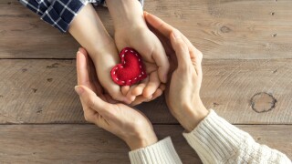 Red,Heart,In,Child,And,Female,Hands,Over,Wooden,Background,