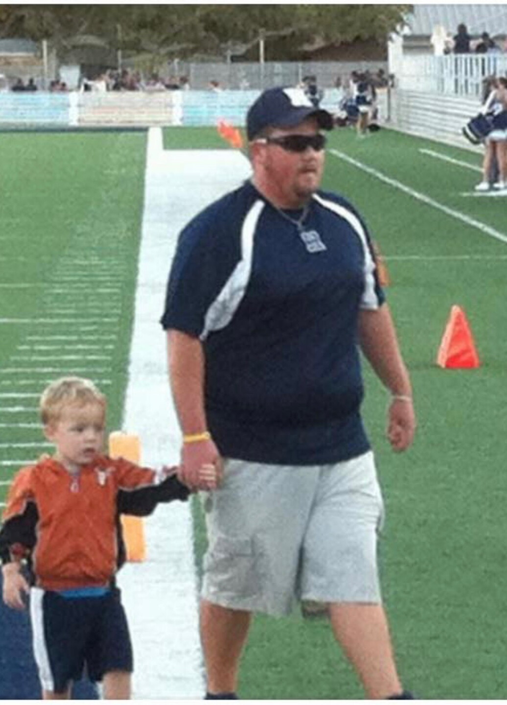 Robstown football head coach Travis Crowley walking with his son Travis