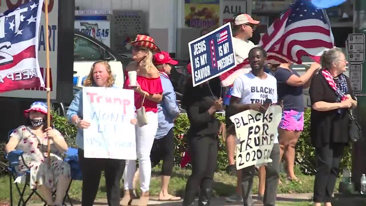 Supporters hold pro-Donald Trump signs at rally, Feb. 15, 2021