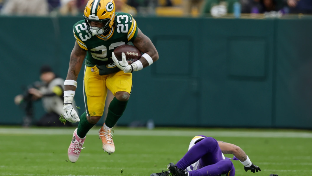 Green Bay Packers running back Emanuel Wilson (27) runs with the football after avoiding a tackle by Minnesota Vikings cornerback Byron Murphy (7), right, during the second half of an NFL football game Sunday, Nov. 23, 2025, in Green Bay.