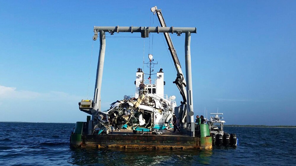 In this July 7, 2019 photo made available by the Bahamas Air Accident Investigation Department, the wreckage of a Augusta SPA helicopter is recovered off the coast of Grand Cay, in the Abacos, Bahamas. Coal billionaire Chris Cline and six other Americans died in the crash on July 4, 2019, as they were departing the Bahamas towards Fort Lauderdale, Fla.