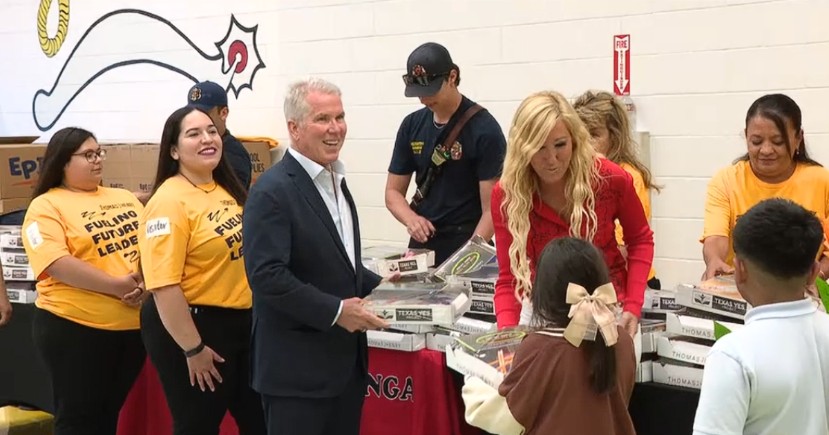 Thomas J. Henry hands out boxes of dreams to students at Berlanga Elementary