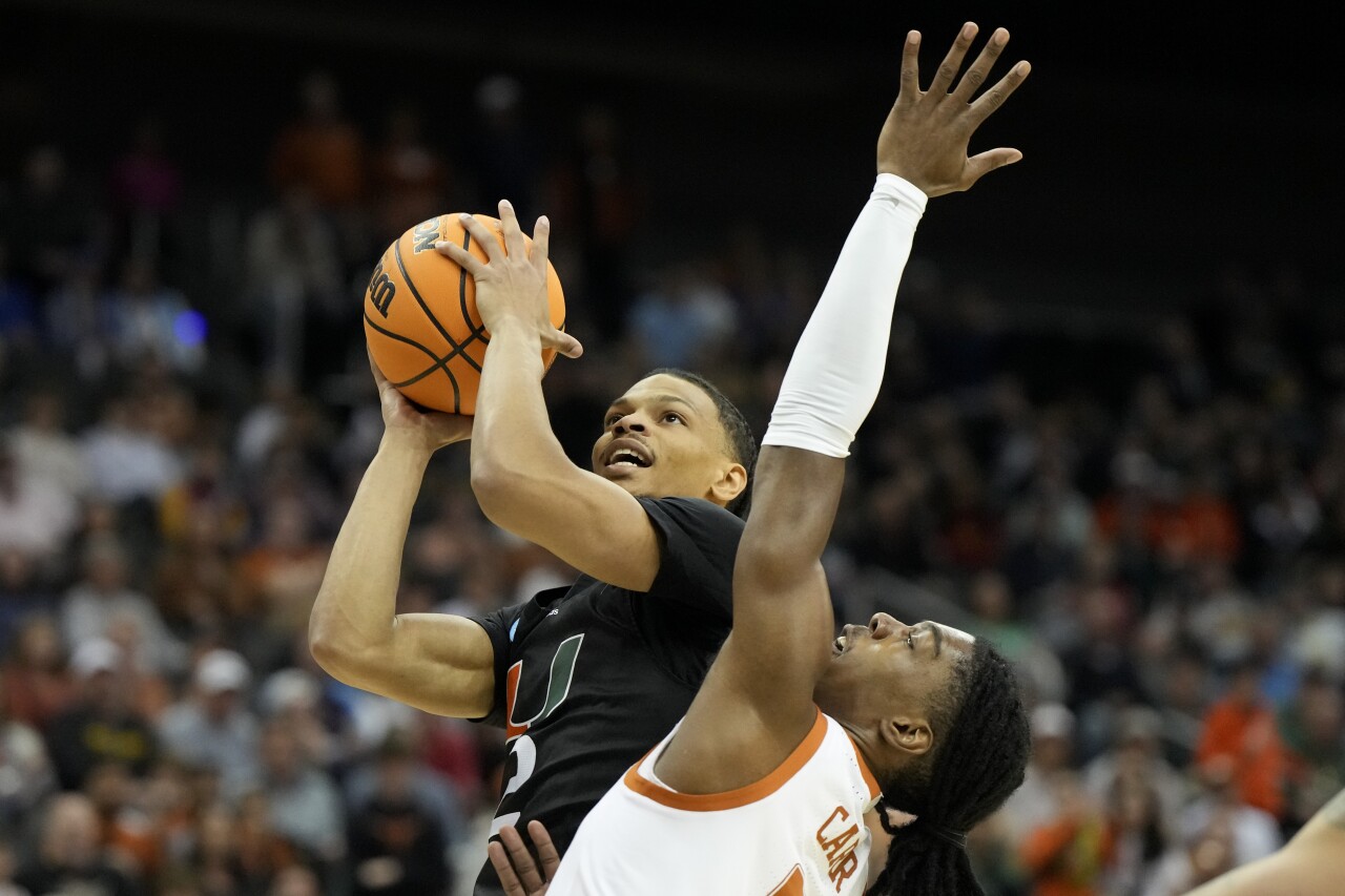 Miami Hurricanes guard Isaiah Wong shoots over Texas Longhorns guard Marcus Carr in first half of Elite Eight game of NCAA tournament, March 26, 2023