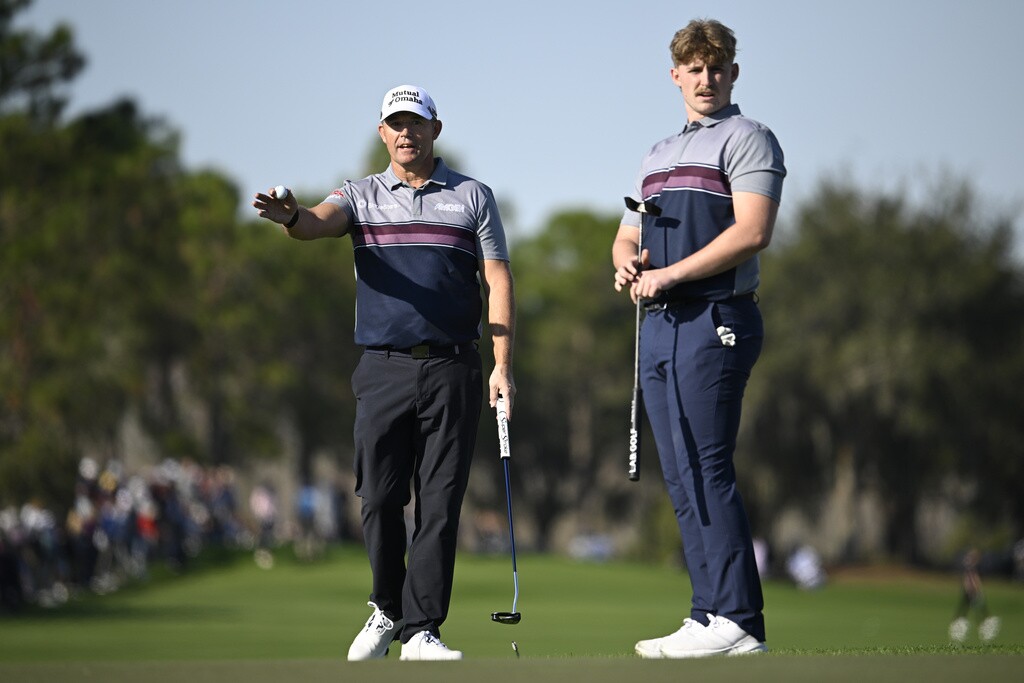 Padraig Harrington, left, and his son Paddy Harrington line up their putt on the 18th green hole during the first round of the PNC Championship golf tournament.