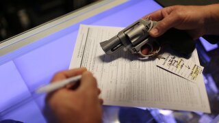 A man fills out his federal background check paperwork as he purchases a handgun.
