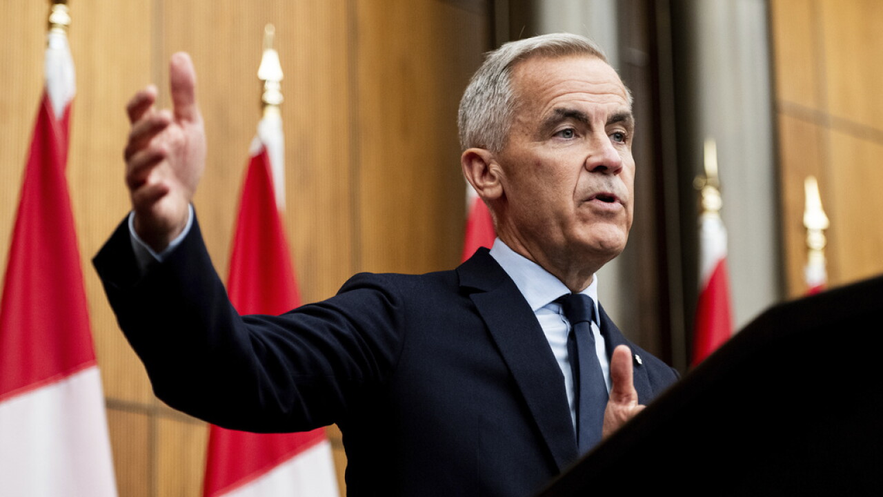 Il primo ministro canadese Mark Carney interviene davanti alle bandiere del Canada