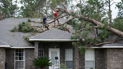 Jeff Lundy cuts up a pine tree that fell on his father-in-law's house during Isaias on Saturday, Oct. 10, 2026, in Milton, Fla. (AP Photo/Octavio Jones)
