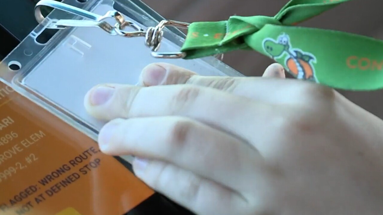 A student swipes an identification card on a Martin County school bus in October of 2021.jpg