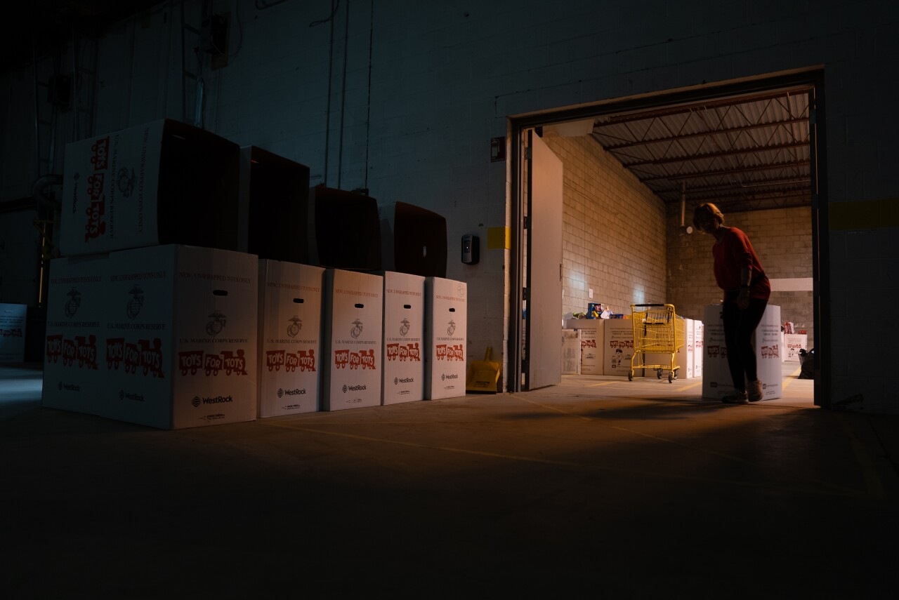 A Toys for Tots volunteer helps sort toys into boxes