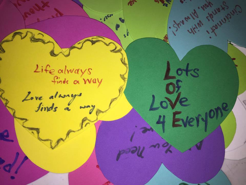 This photo shows handmade hearts that were given away as part of Love Must Win's Hearts and Hugs Project. One green heart in the photo says, "Loves of Love 4 Everyone."