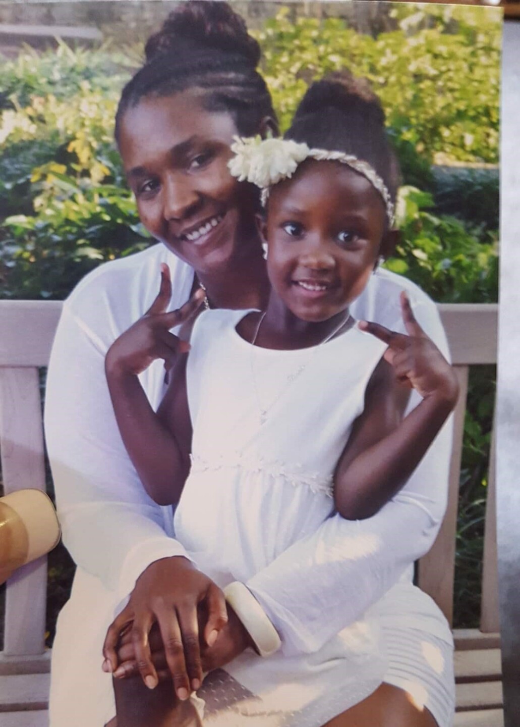 Kendra Davis and her daughter smile in an undated photo. Both are wearing white, and Davis's daughter is sitting on her lap.