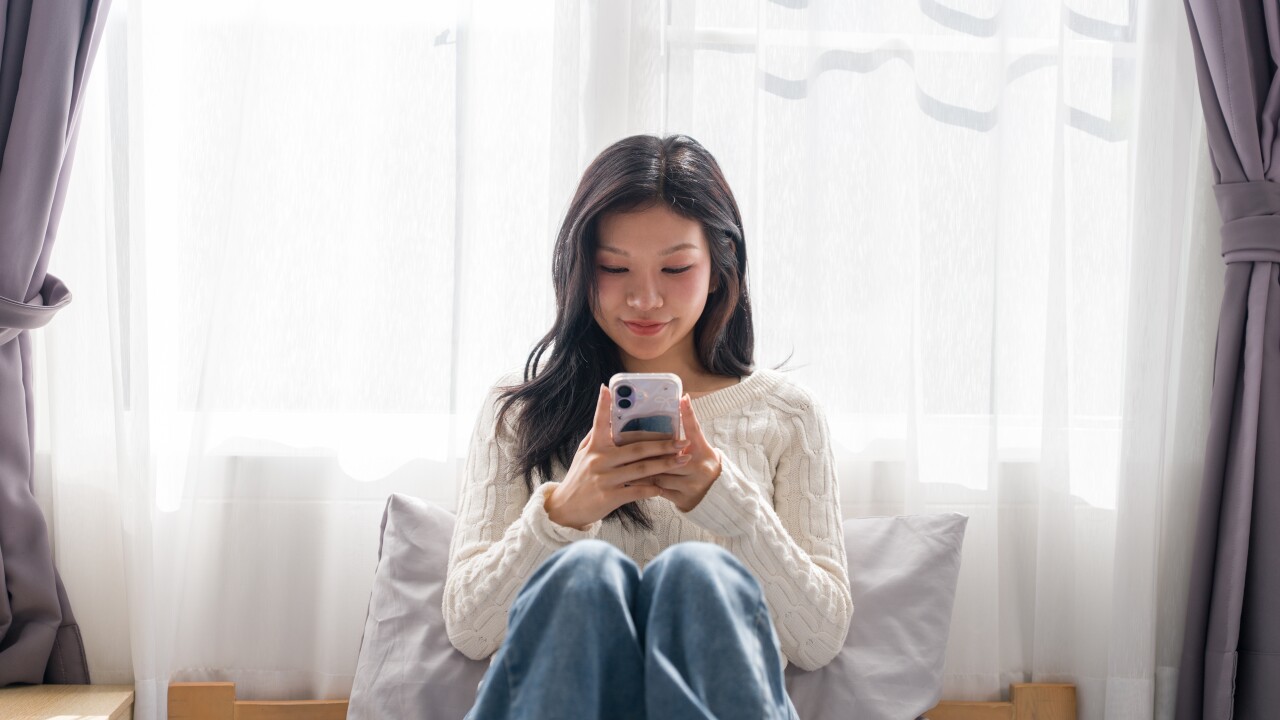 Young,Asian,Woman,Sitting,On,Bed,Using,Smartphone,Mobile,Phone