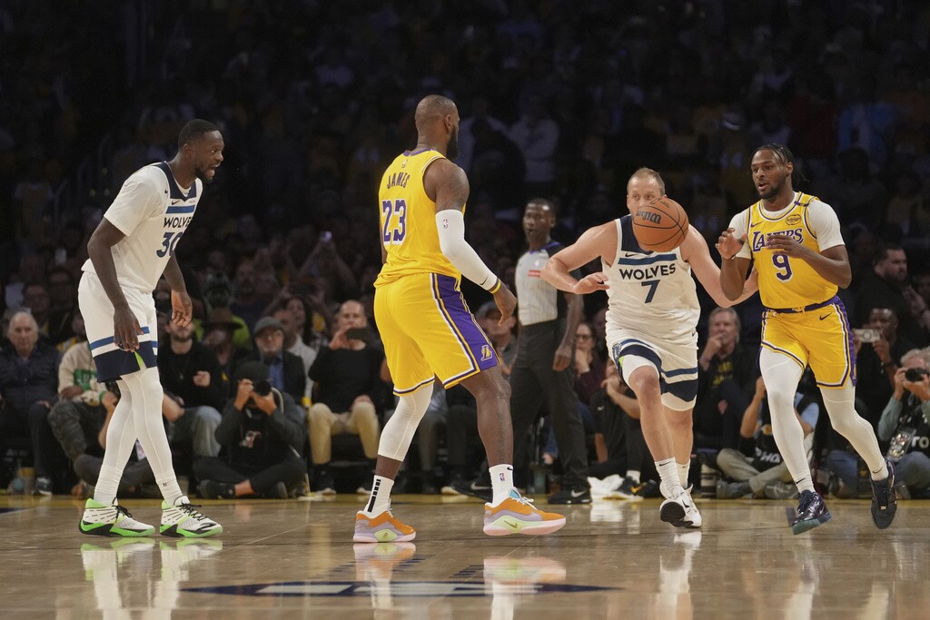 Los Angeles Lakers forward LeBron James passes to guard Bronny James during the first half of an NBA basketball game against the Minnesota Timberwolves