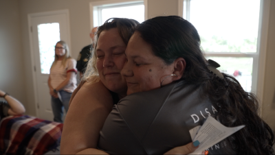 Kaylee Sandin gives her disaster case manager, Maribel Rico, with SendMeMissions a hug.